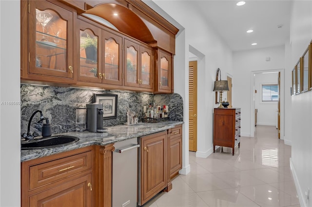 bar featuring light tile patterned flooring, light stone counters, sink, and tasteful backsplash