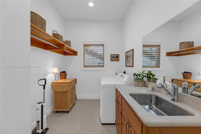 laundry area with washer and clothes dryer, light tile patterned flooring, and sink