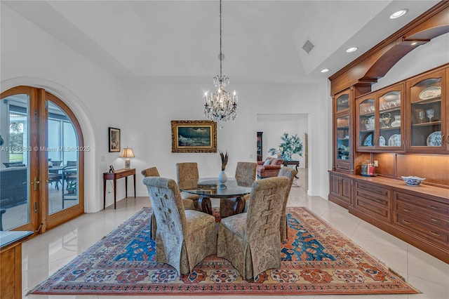 dining space with light tile patterned floors, an inviting chandelier, french doors, and lofted ceiling