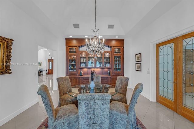 dining room with french doors, light tile patterned flooring, and a chandelier