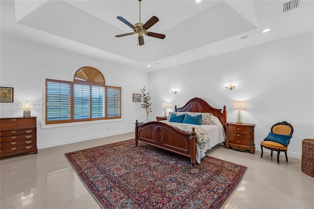 tiled bedroom featuring a raised ceiling and ceiling fan