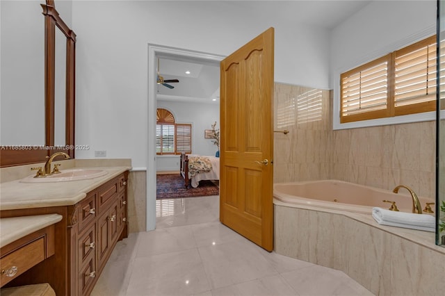 bathroom featuring a relaxing tiled tub, vanity, ceiling fan, and tile patterned floors