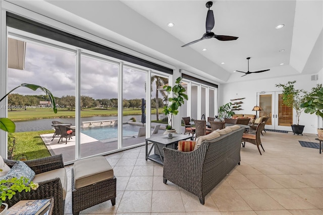 tiled living room featuring ceiling fan and a raised ceiling