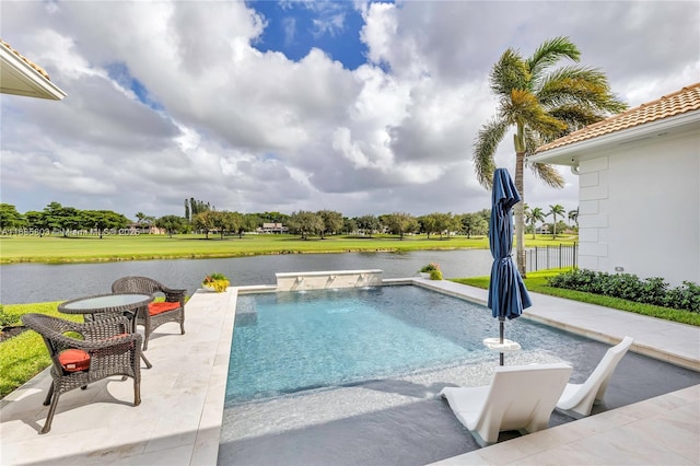 view of swimming pool with pool water feature, a water view, and a patio