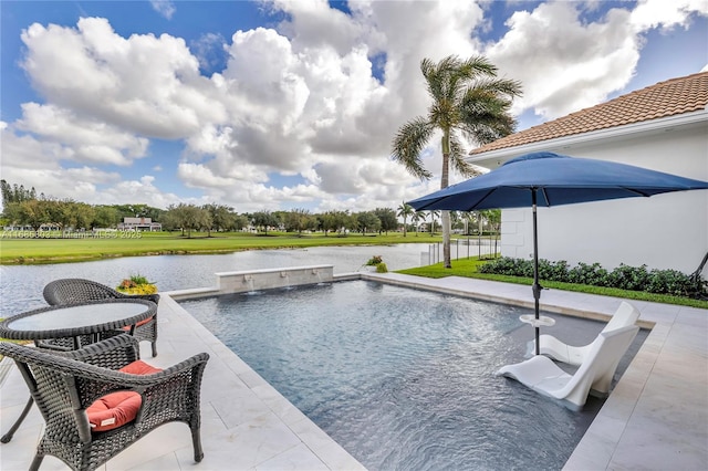 view of pool with a patio, a water view, and pool water feature