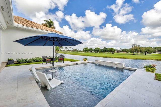 view of swimming pool featuring pool water feature, a water view, and a patio