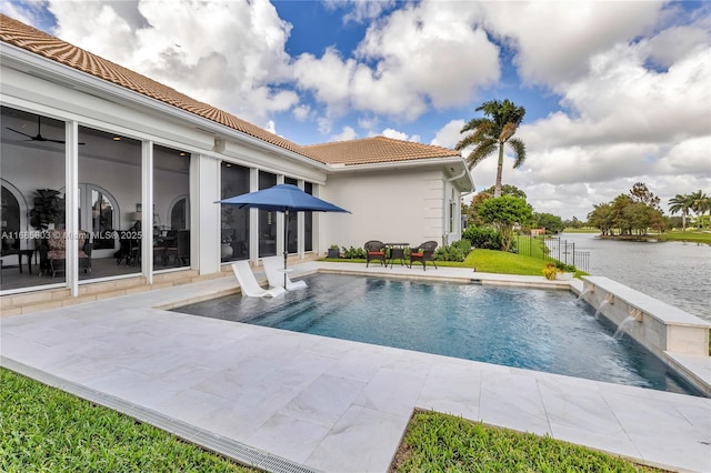 view of pool with a patio area, pool water feature, and a water view