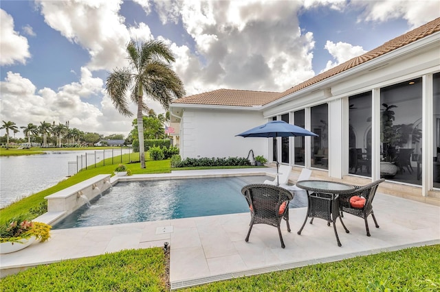 view of swimming pool with pool water feature, a water view, and a patio area