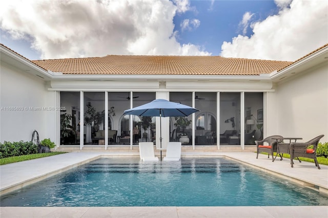 view of swimming pool featuring a patio, ceiling fan, and a sunroom