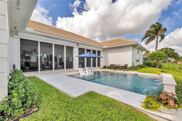 view of swimming pool featuring pool water feature, a patio, and a lawn