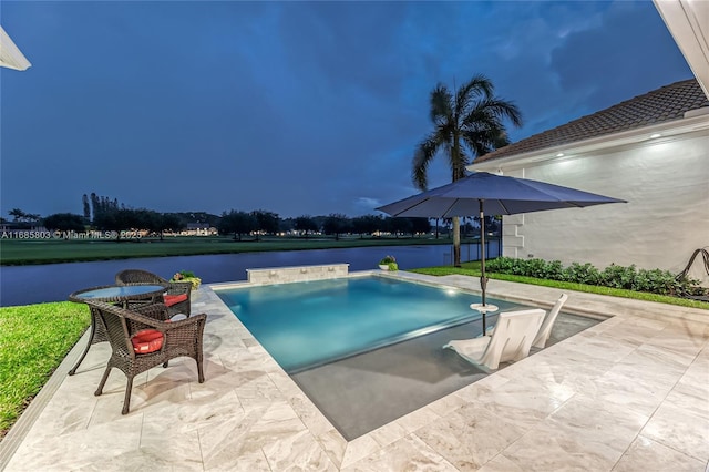 view of pool with a water view and a patio