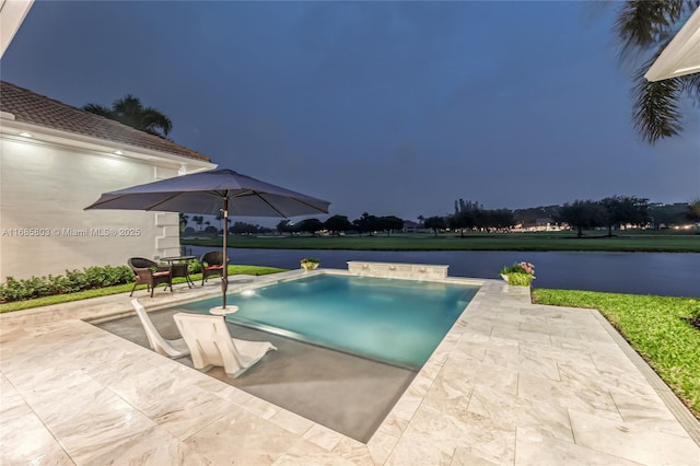 view of pool featuring a patio area and a water view