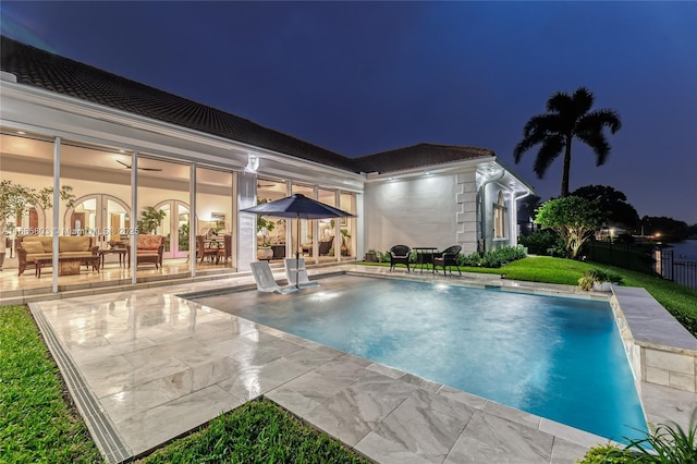 pool at twilight featuring a patio