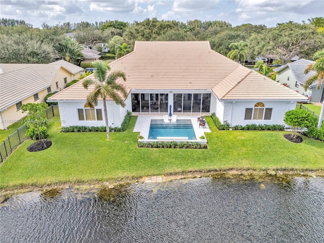 rear view of house featuring a water view, a yard, and a patio