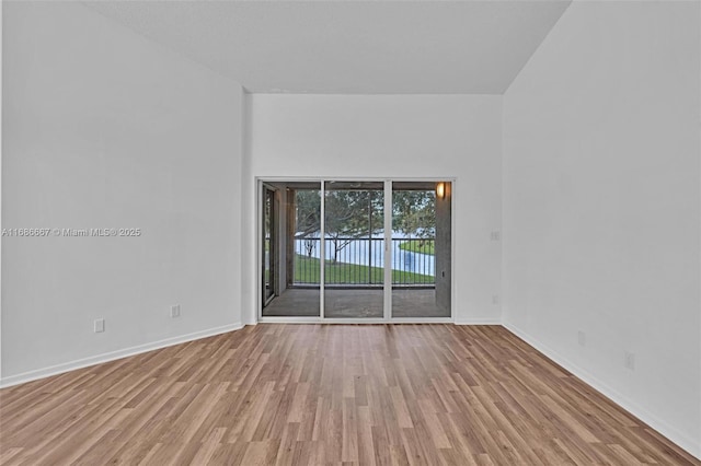 empty room featuring light wood-type flooring and baseboards