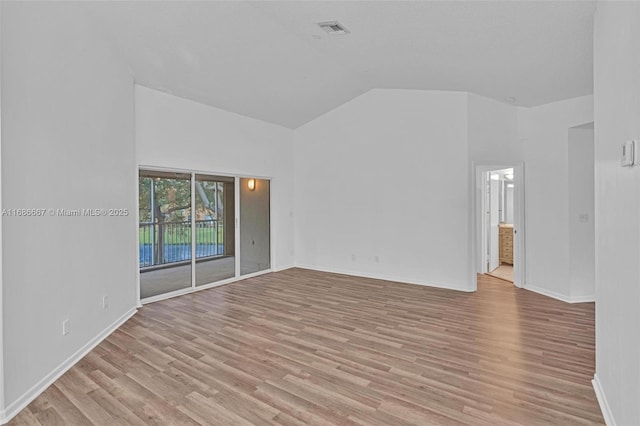 unfurnished room with light wood-style floors, visible vents, high vaulted ceiling, and baseboards