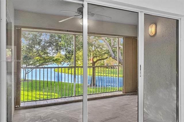 doorway to outside with a wealth of natural light, a water view, and ceiling fan