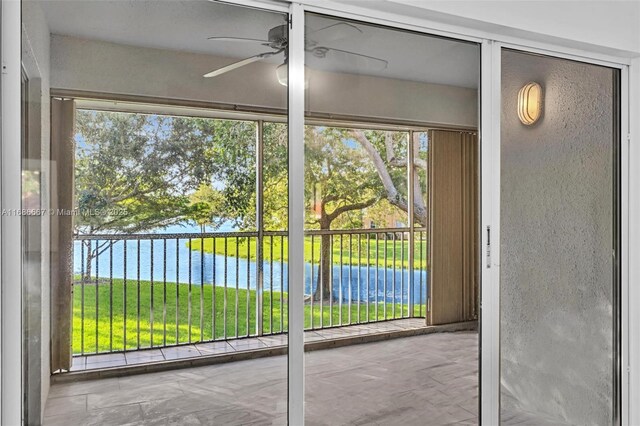 entryway featuring a healthy amount of sunlight, a water view, and ceiling fan