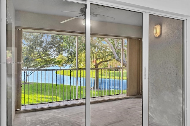 doorway with a ceiling fan and a water view