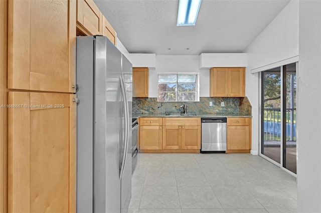 kitchen featuring decorative backsplash, dark stone counters, stainless steel appliances, a sink, and light tile patterned flooring