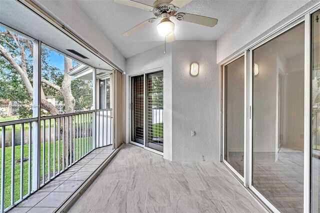 unfurnished sunroom with ceiling fan