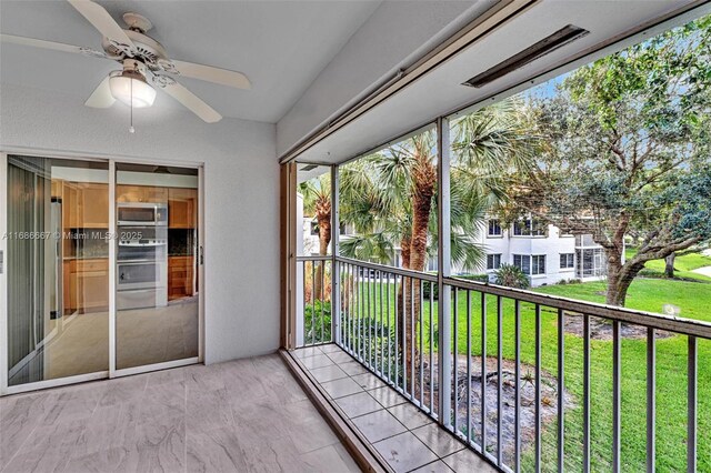 unfurnished sunroom with ceiling fan