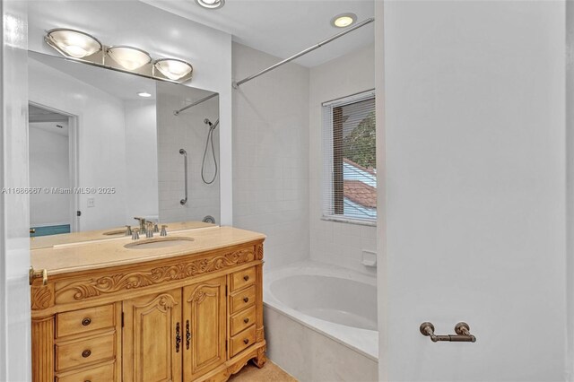 bathroom featuring tiled shower / bath and vanity