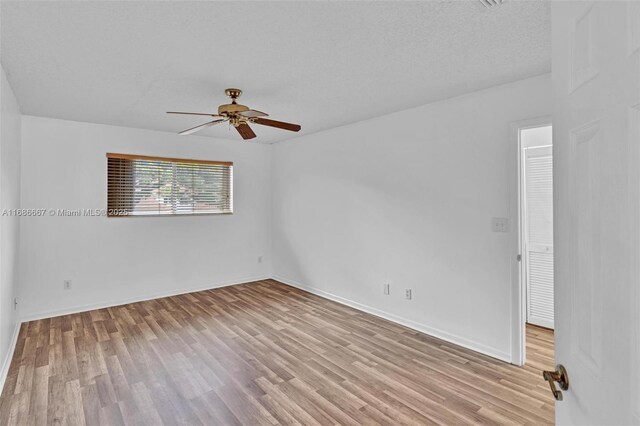 empty room featuring light hardwood / wood-style floors, a textured ceiling, and ceiling fan