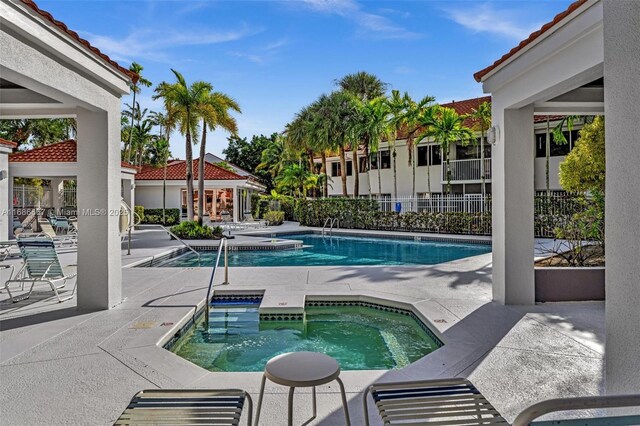 view of swimming pool with a community hot tub and a patio