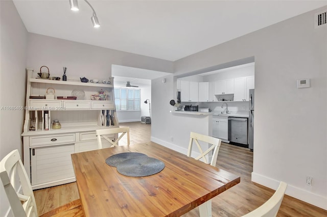 dining room with ceiling fan and light hardwood / wood-style flooring