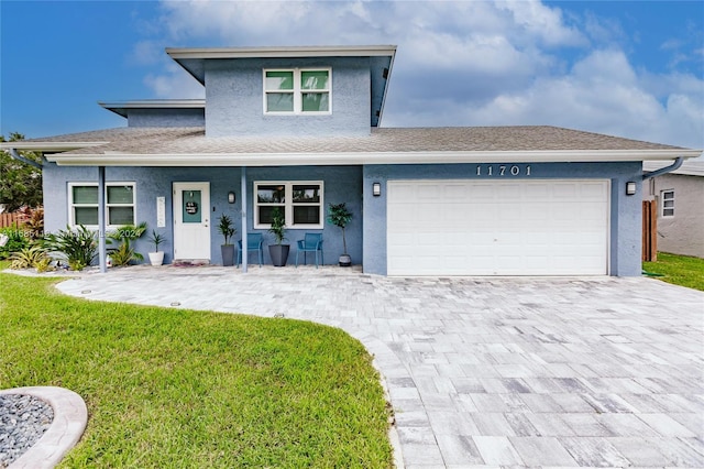 front facade with a garage, a front yard, and covered porch