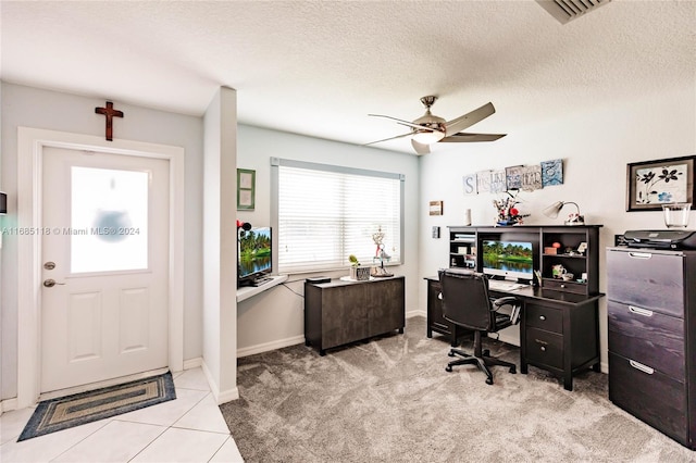 office area with a textured ceiling, light colored carpet, and ceiling fan