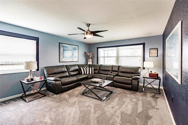 carpeted living room with ceiling fan and a textured ceiling