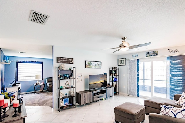 tiled living room featuring a textured ceiling and ceiling fan