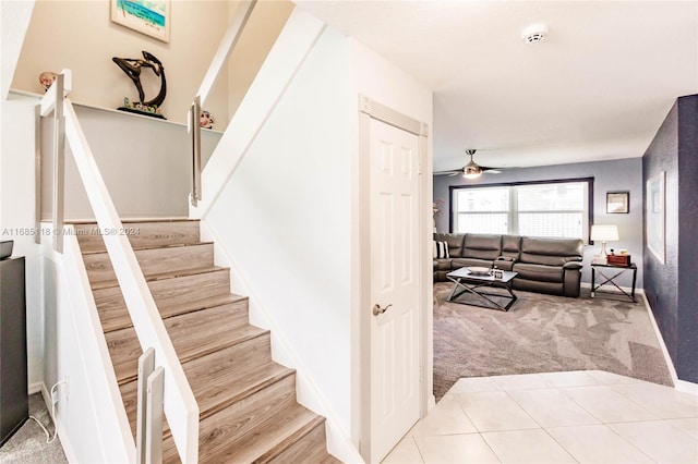 stairs featuring carpet and ceiling fan