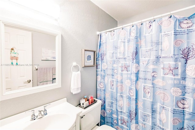 bathroom featuring toilet, a shower with curtain, and vanity