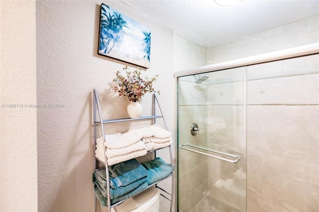 bathroom with toilet, a textured ceiling, and walk in shower