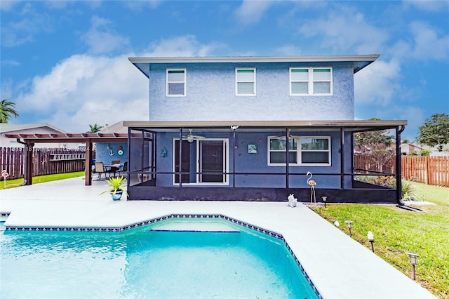 back of house featuring a fenced in pool, a patio, a lawn, and ceiling fan