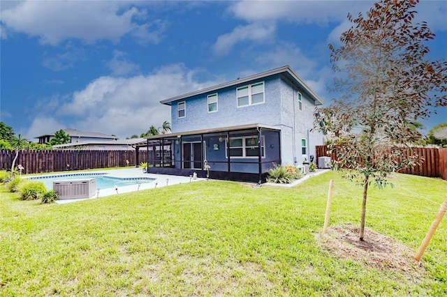 rear view of property featuring a sunroom, a yard, a swimming pool with hot tub, and cooling unit