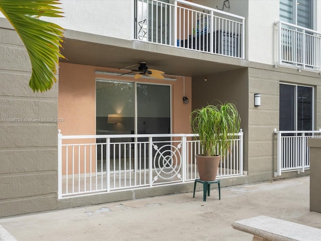 entrance to property with ceiling fan and a balcony