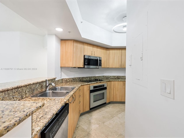 kitchen with stainless steel appliances, light brown cabinetry, light stone countertops, and sink