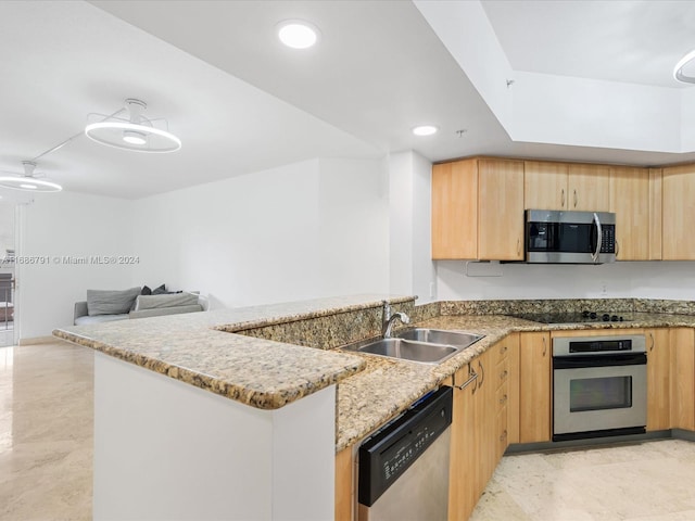 kitchen featuring kitchen peninsula, sink, light stone countertops, appliances with stainless steel finishes, and light brown cabinetry