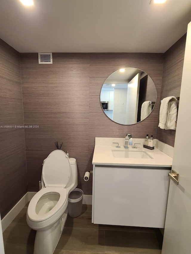 bathroom featuring toilet, vanity, and tile patterned floors