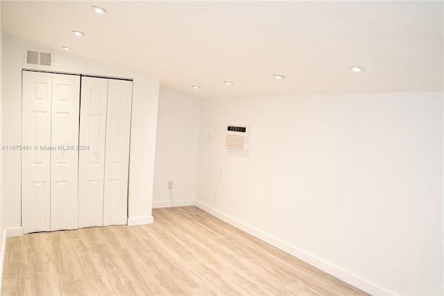 unfurnished bedroom with a closet, light hardwood / wood-style floors, and lofted ceiling