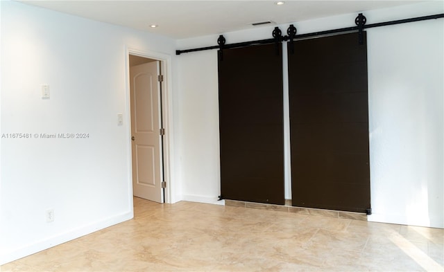 spare room featuring a barn door