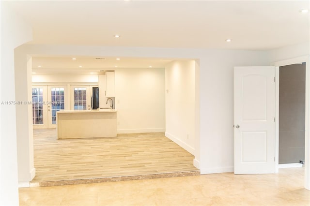 empty room featuring light hardwood / wood-style floors, french doors, and sink