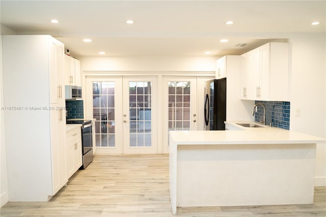 kitchen with white cabinetry, appliances with stainless steel finishes, sink, and decorative backsplash