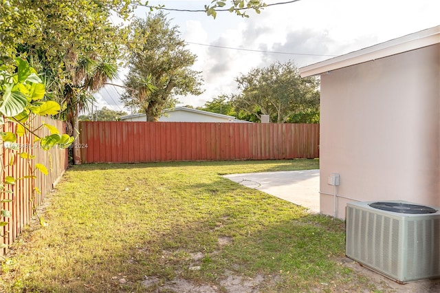 view of yard with central air condition unit and a patio area