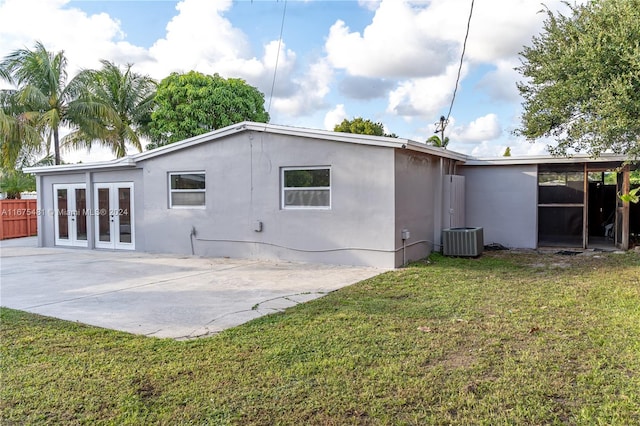 rear view of property featuring french doors, a yard, central air condition unit, and a patio area