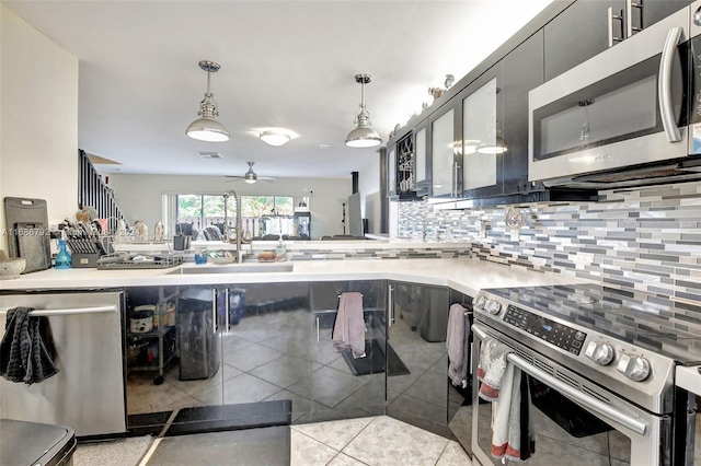 kitchen with sink, light tile patterned floors, decorative light fixtures, and appliances with stainless steel finishes